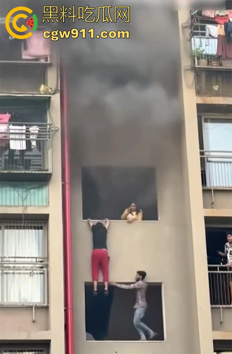 印尼某小区发生火灾，电瓶车爆燃无法下楼，两男子化身超人，在楼下窗口接孩子，实在太惊险了！-2